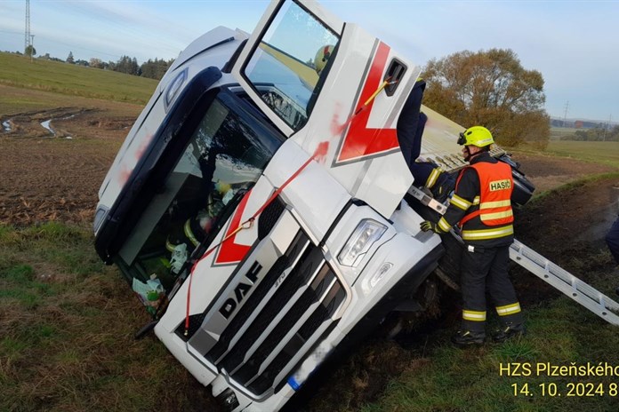 Řidič neovládl v zatáčce kamion, skončil v příkopě. Vyprošťovat ho museli hasiči